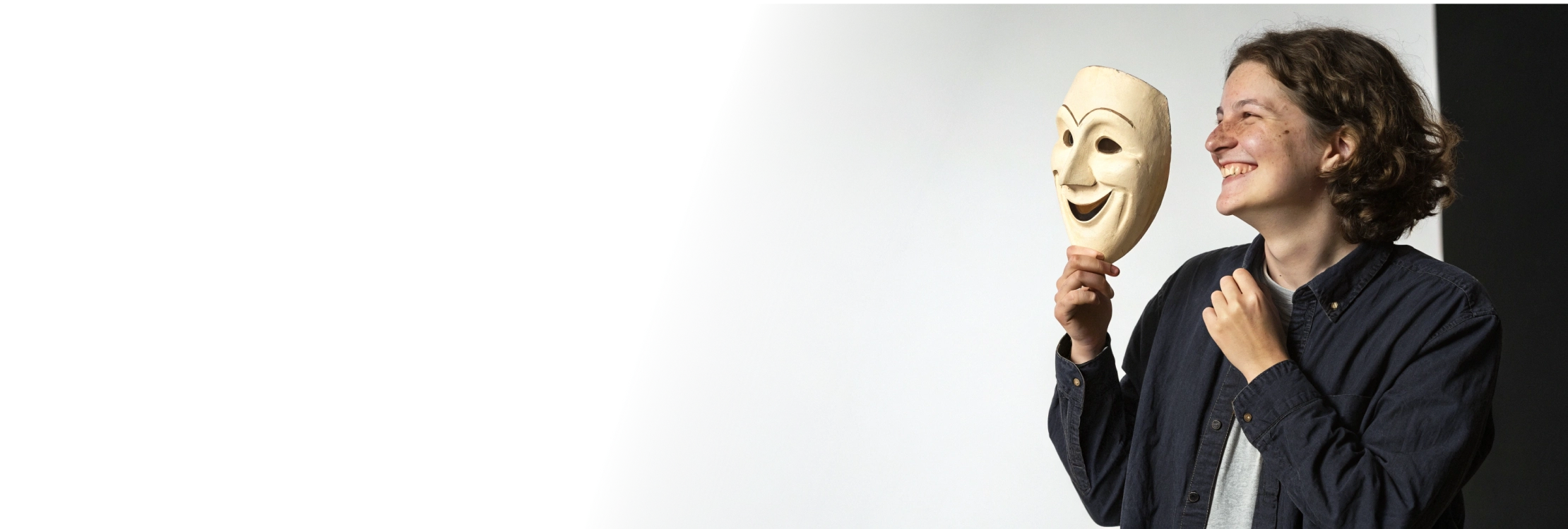 Оставьте запрос анонимно и выберите подходящего психолога Улыбающийся человек держит театральную маску символ анонимного обращения к психологу